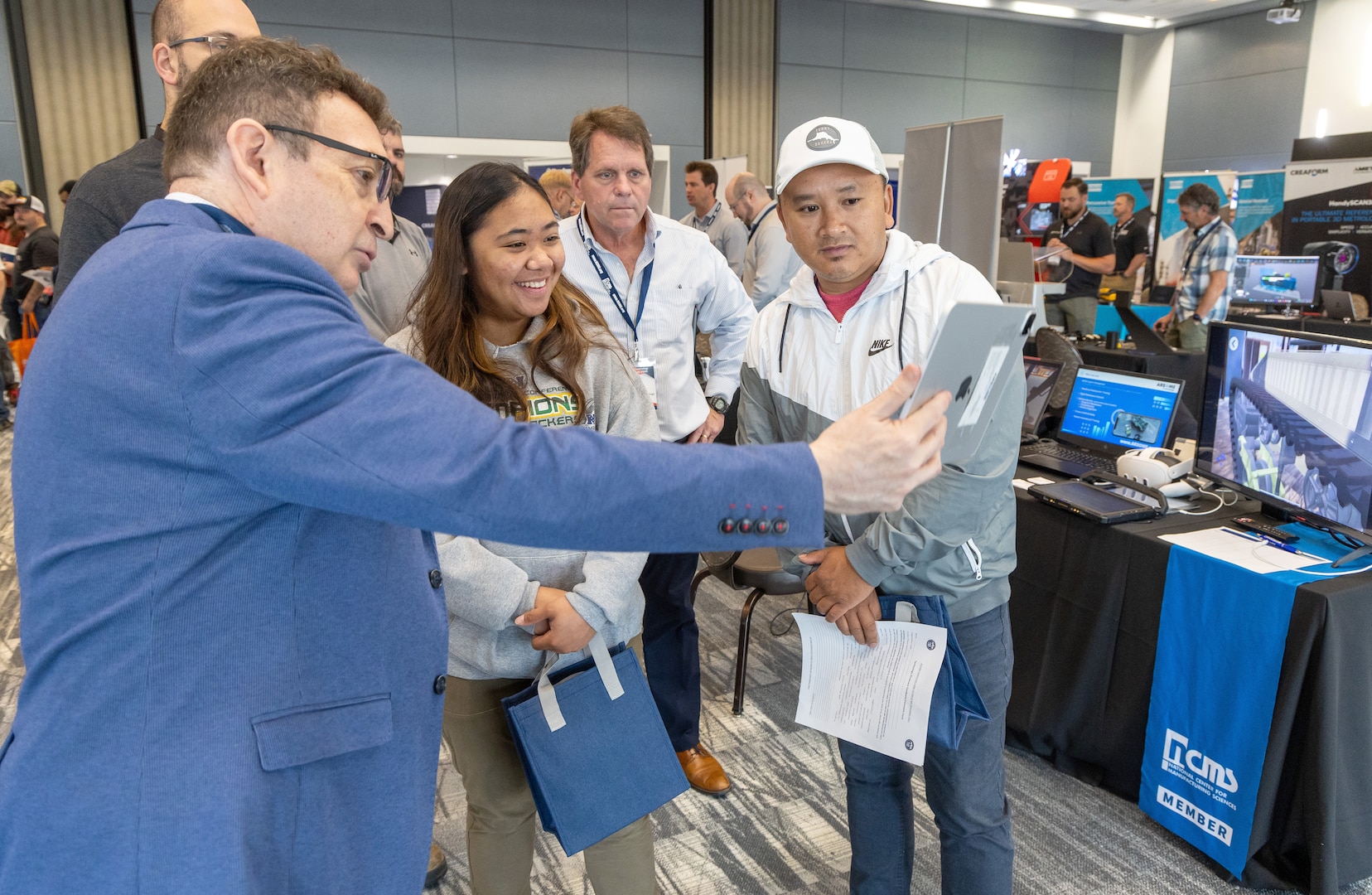 Kayla Guevarra and Giang Phang, both insulator helpers, Shop 57, Pipe Insulators, watch a demonstration with ARSME Technology representative Joseph Wysocki July 31, 2024, during the annual PSNS & IMF Technology Showcase at the Kitsap Conference Center in downtown Bremerton, Washington. (U.S Navy Photo by Wendy Hallmark)