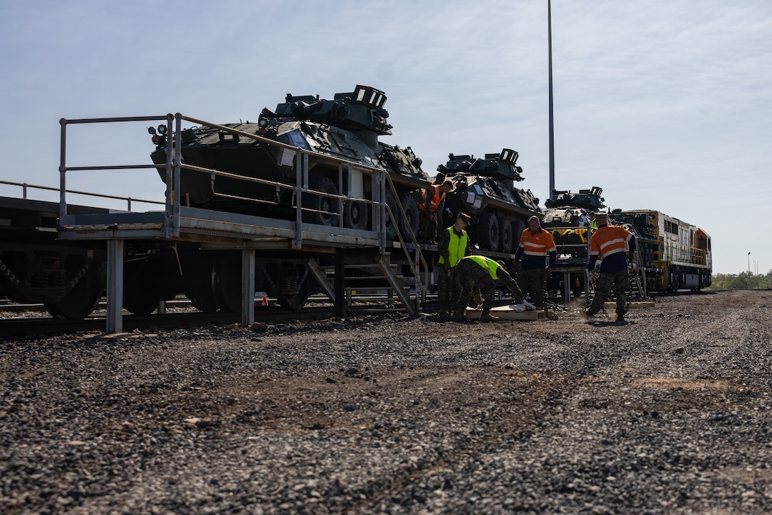 U.S. Marines with Alpha Company, 1st Light Armored Reconnaissance Battalion, 1st Marine Division, unload LAV-25 Light Armored Vehicles at the Berrimah Railyard during Rapid Deployment Exercise at Darwin, NT, Australia, July 21, 2024. REDEX is a 1st MARDIV training exercise, with this year’s iteration planned in conjunction with Marine Rotational Force – Darwin 24.3, to rehearse the ability to rapidly deploy capabilities from Marine Corps Base Camp Pendleton, California, U.S., to Australia. 1st LAR tested the logistical efficiency and unit readiness required to rapidly deploy a heavy equipment unit within the U.S. Indo-Pacific Command theater by strategic lift and rail to participate in Exercise Predator’s Run 24. (U.S. Marine Corps photo by Cpl. Earik Barton)