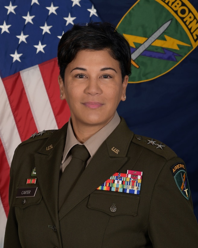 Major General Andrée G. Carter, commanding general, U.S. Army Civil Affairs & Psychological Operations Command (ABN) poses for her command photo in front of the United States flag and U.S. Army Civil Affairs and Psychological Operations Command (Airborne) unit colors.