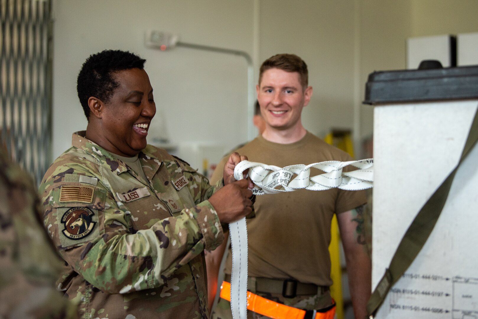 U.S. Air Force Senior Master Sgt. Shantella R. Glass, assigned to Volk Field Air National Guard base, left, and Tech. Sgt. Dylan F. Naquin, right, assigned to the 128th Air Refueling Wing, Milwaukee, WI, learns how to properly braid an ammo knot during pallet training at Volk Field Air National Guard base, Camp Douglas, Wisconsin, July 17, 2024. As part of the agile combat employment (ACE) training, Airmen were trained in different areas of their job operations to ensure multi-capability, interoperability, and efficiency during deployment and wartime situations. (U.S. Air National Guard photo by Airman 1st Class Cynthia Yang)