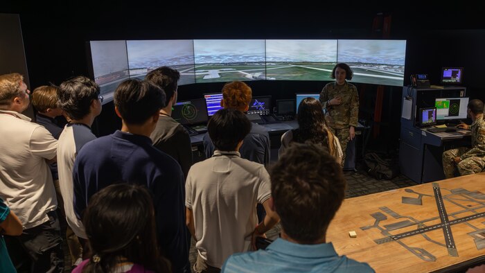 High school students look at air traffic control tower simulator