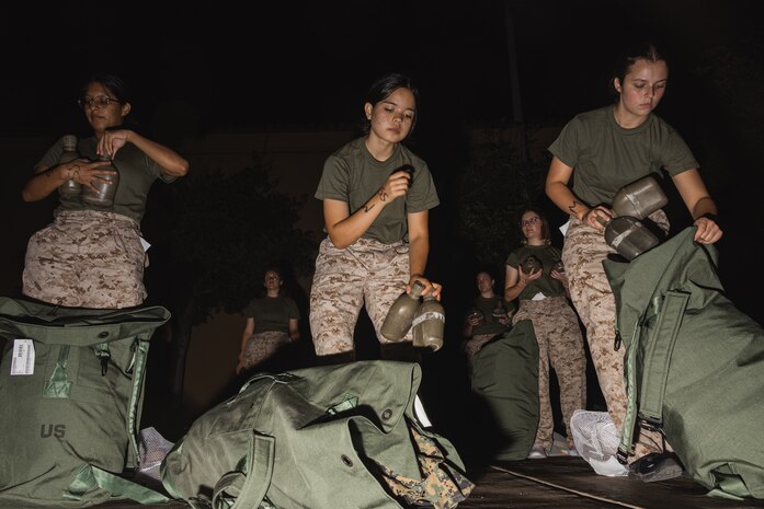 U.S. Marine Corps Recruits Theresa Lizarde, left, Nida Amini, center, and Cianna Pruitt, right, all with Delta Company, 1st Recruit Training Battalion, are issued their gear required for training as part of a receiving event at Marine Corps Recruit Depot San Diego, California, Aug. 5, 2024. During the receiving process recruits are checked for contraband, given haircuts, make scripted phone calls home, and are issued the gear required for their training.  (U.S. Marine Corps photo by Lance Cpl. Janell B. Alvarez)
