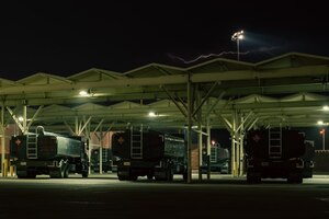 Refueler trucks sit under a canopy.