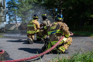 Fire cadets and fireman hold fire hose