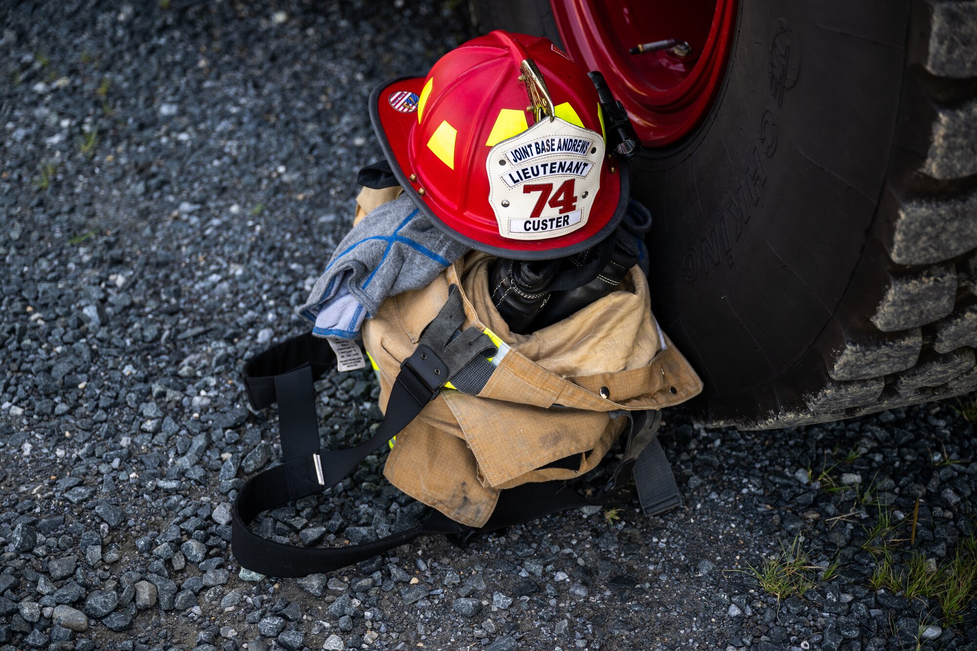 Fire helmet sits by fire truck tire