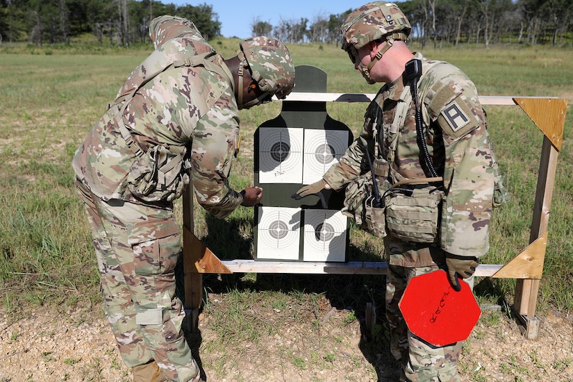 Sgt. 1st Class Chris Duncan, right, active-duty Senior OC/T, 1-338th TSBN, Fort McCoy, Wisconsin, examines a zero target with Master Sgt. Winston Allen, Weapons Non-Commissioned Officer in Charge, 1-338th Training Support Battalion, August 7, 2024.