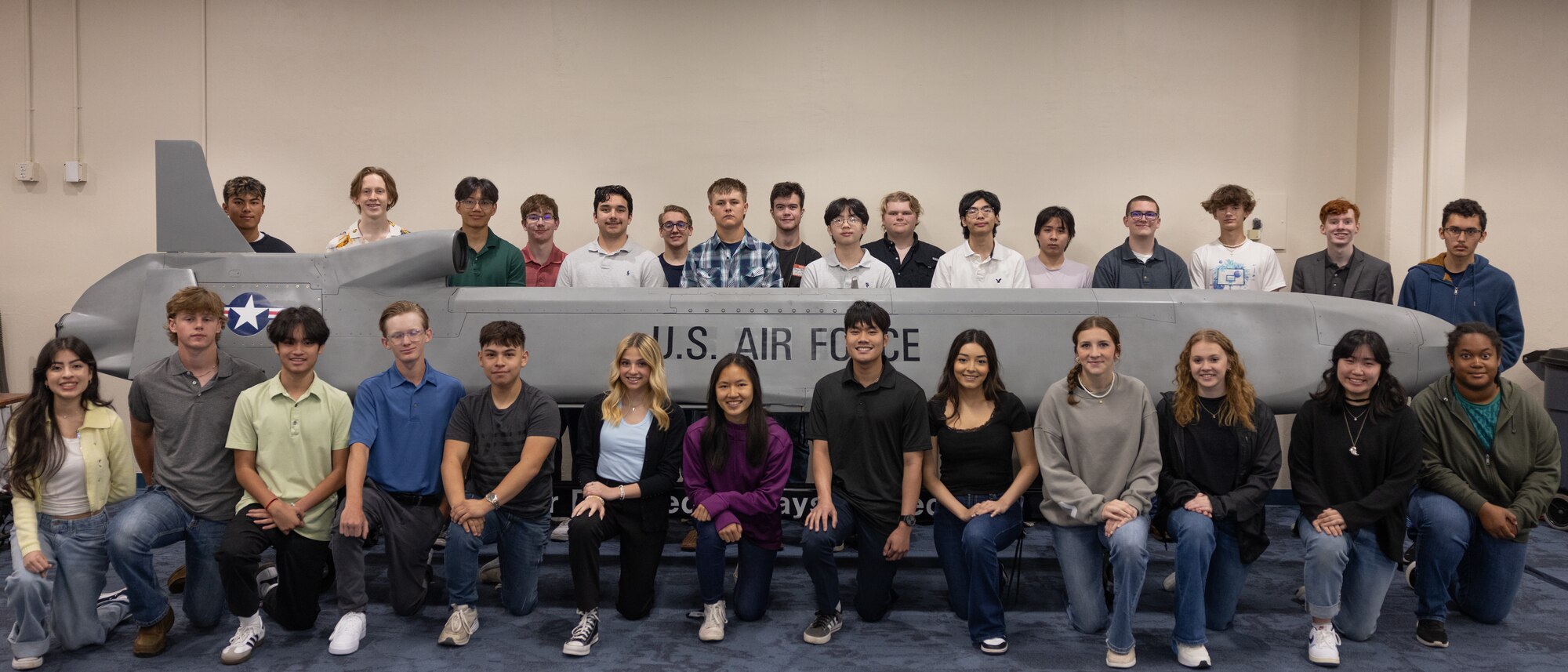 High school students posing for group photo in front of cruise missile
