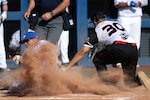 Air Force Tech Sgt. Todd Duncan beats a tag at home plate by Marine Corps Staff Sgt. Luis Mendez during the 2024 Armed Forces Men’s and Women’s Softball Championship hosted by USA Softball at the USA Softball National Hall of Fame Complex in Oklahoma City Aug 14, 2024. (DoD photo by EJ Hersom)