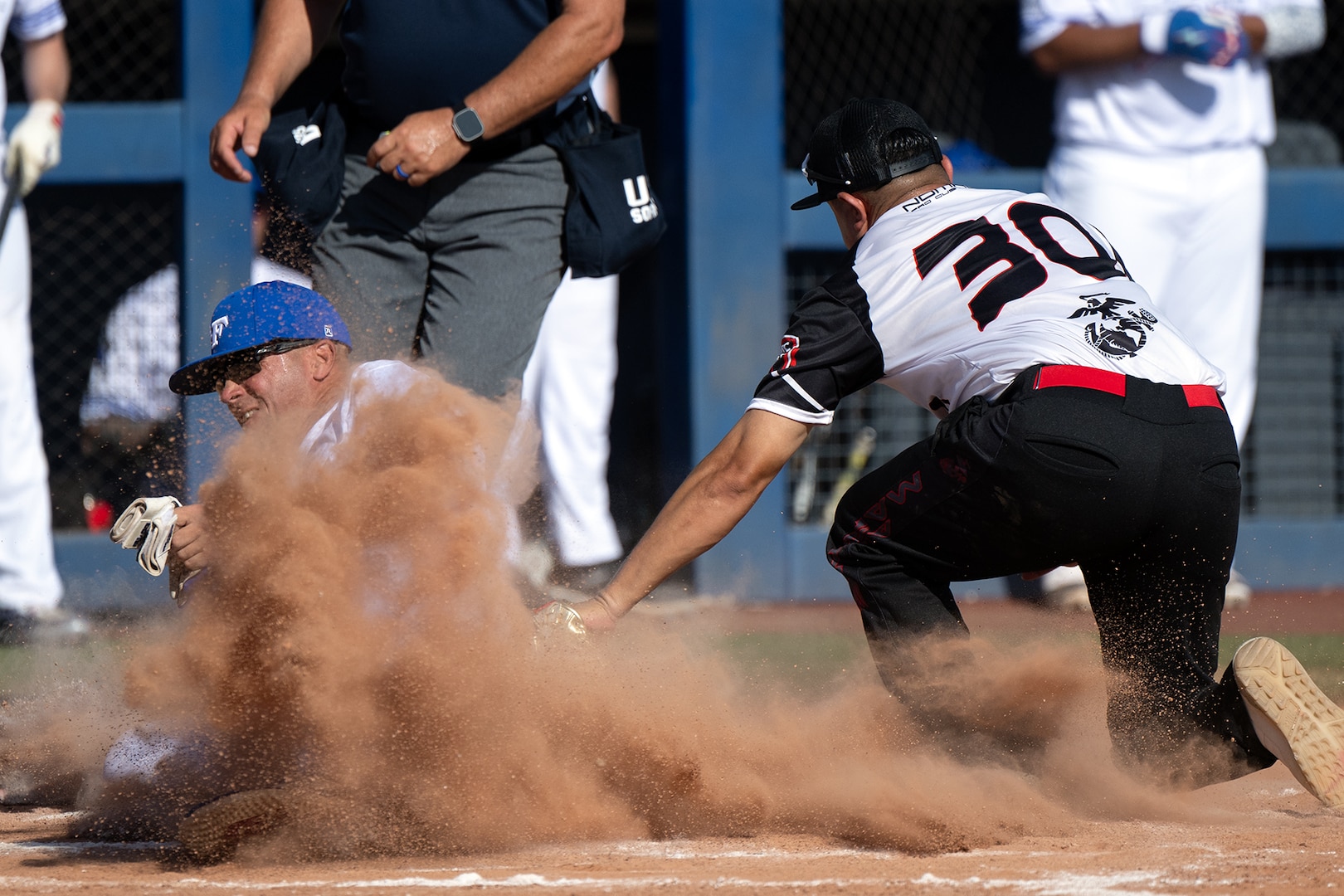 Air Force Tech Sgt. Todd Duncan beats a tag at home plate by Marine Corps Staff Sgt. Luis Mendez during the 2024 Armed Forces Men’s and Women’s Softball Championship hosted by USA Softball at the USA Softball National Hall of Fame Complex in Oklahoma City Aug 14, 2024. (DoD photo by EJ Hersom)