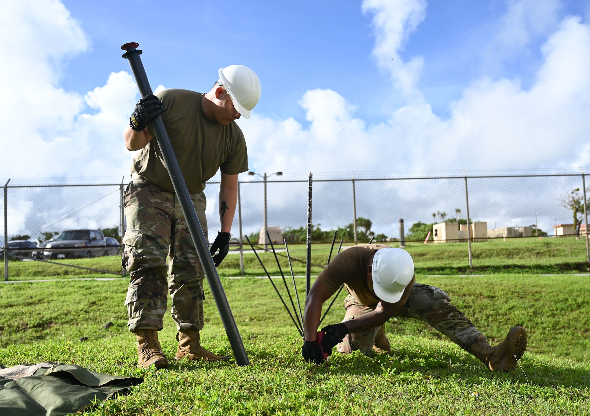 Airmen from the 293rd and 644th Combat Communications Squadron set up an antenna on grass.