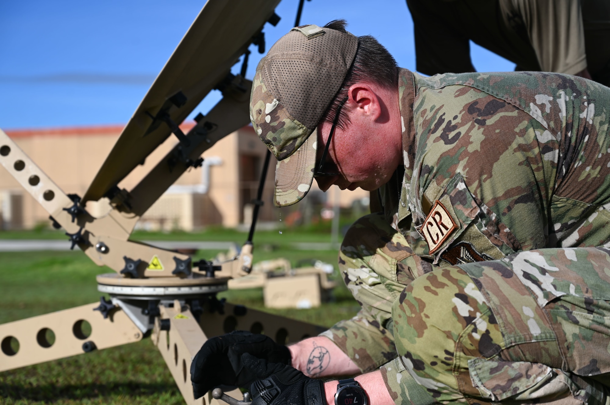 An Airman secures a satellite communication dish.