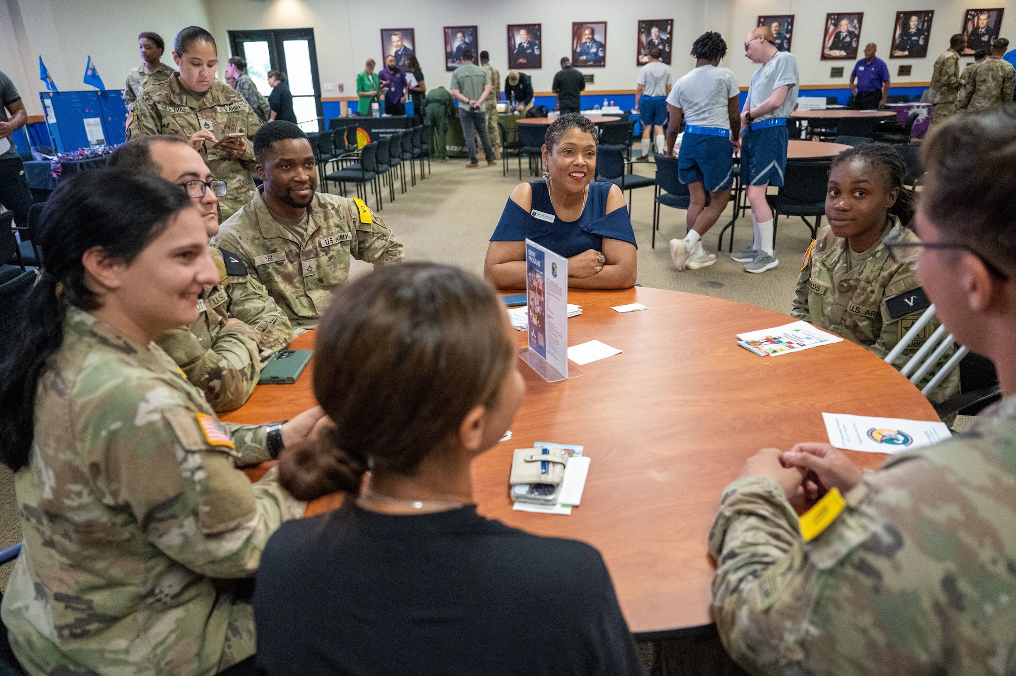 Kelli Williams, DRIVE (Develop, Redistribute, Improve, Vault, Expose) program manager, engages with 737th Training Group trainees around a table at the DRIVE Joint Forces Employment Fast Track event on June 28, 2024, at the Pfingston Reception Center on Joint Base San Antonio-Lackland.