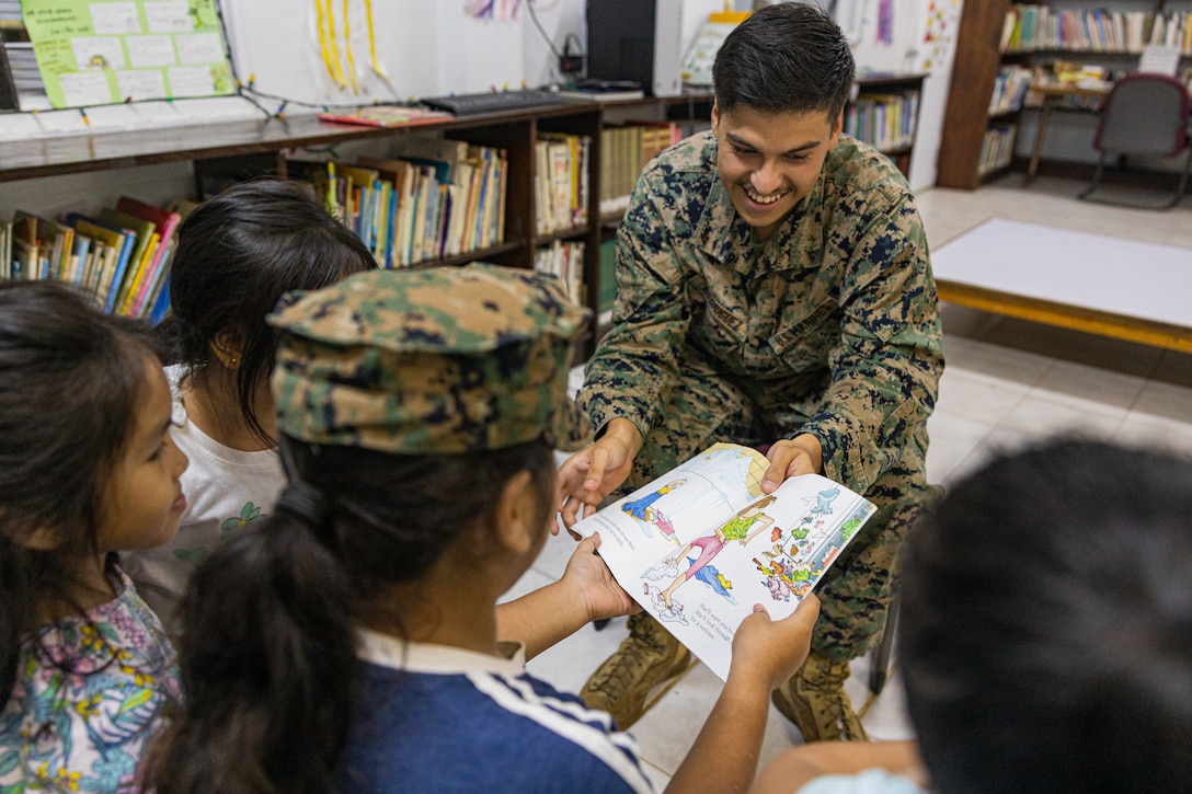 U.S. Marine Corps Lance Cpl. Jorge Rodriguez, a logistics specialist with Combat Logistics Battalion 13, Combat Logistics Regiment 17, 1st Marine Logistics Group, and native of Oxnard, California, reads a book to kids in the Pohnpei Public Library after helping unload the boxes of book during exercise Koa Moana 24 at Kolonia, Pohnpei, Federated States of Micronesia, Aug. 1, 2024