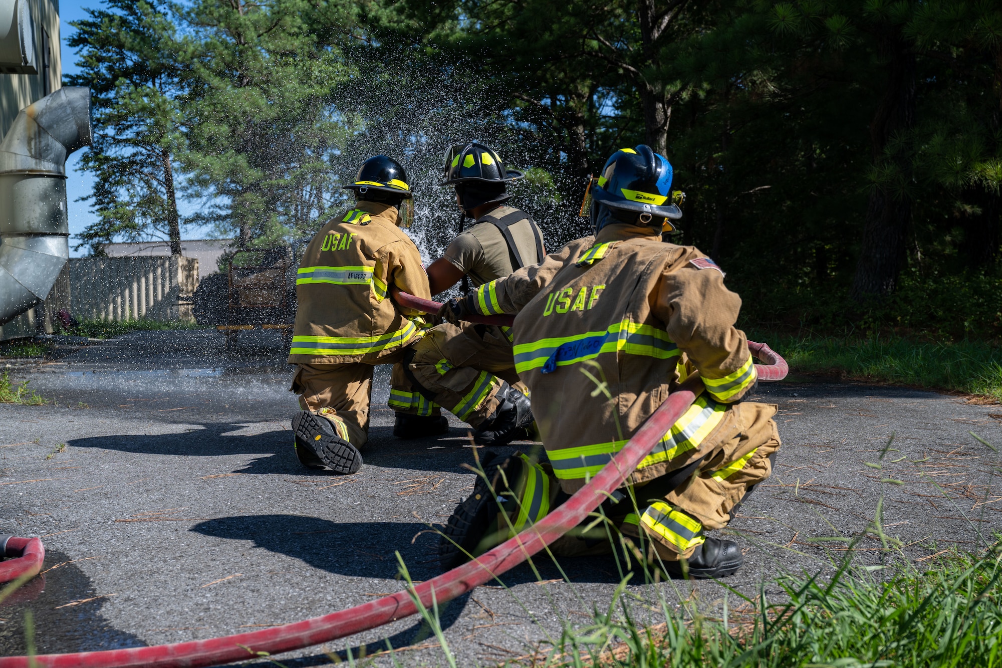 Fire cadets and fireman hold fire hose