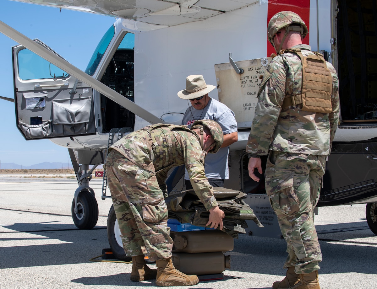 Staff Sgt. Michael Hall, left, and Staff Sgt. Clayton Johnson, fuel specialists from the 9th Reconnaissance Wing, weigh supplies before loading into the autonomous Cessna 208B Grand Caravan from Reliable Robotics, an AFWERX Autonomy Prime partner, during AGILE FLAG 24-3 at Edwards Air Force Base, Calif., Aug. 5, 2024.