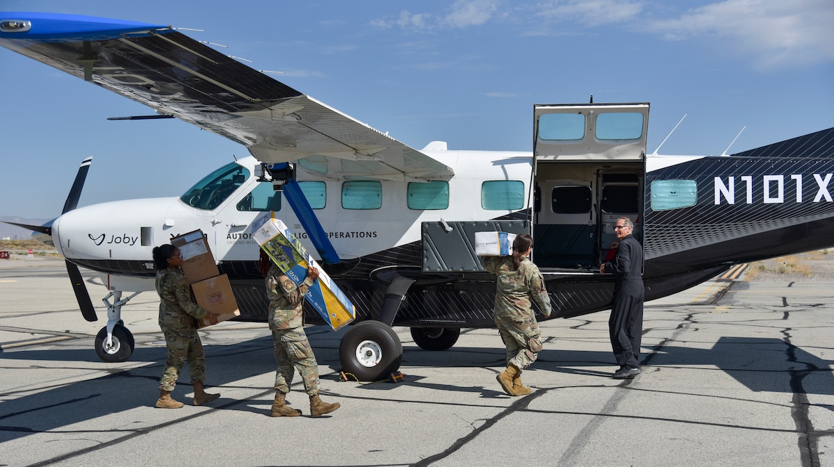 From left, Senior Airman Hailey Jackson, 9th Logistics Readiness Squadron decentralized materiel support, Senior Airman Shenice McCormick, 9th Logistics Readiness Squadron flight service center technician, and Capt. Mackenzie Thompson, 480th Fighter Squadron flight commander, load cargo onto Joby's autonomous Cessna 208B Grand Caravan, an AFWERX Autonomy Prime partner, at Edwards Air Force Base, Calif., during AGILE FLAG 24-3 on Aug. 6, 2024.