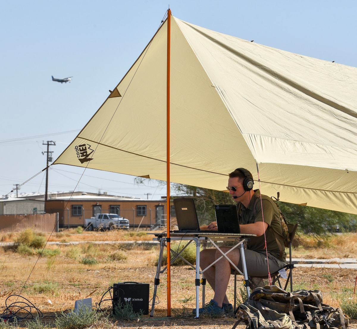 Craig Milliard, Joby’s flight test lead, observes an autonomous flight from the Joby portable ground control station at Mojave Air and Space Port, Calif., as Joby's autonomous Cessna 208B Grand Caravan takes off to Edwards Air Force Base, Calif., in the background during AGILE FLAG 24-3 on Aug. 9, 2024.