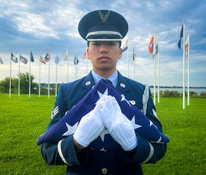 Airman carrying American Flag.