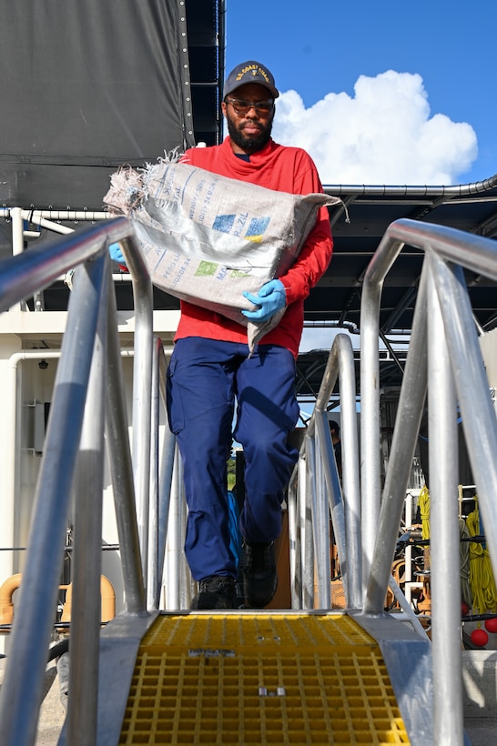 A crew member of the Coast Guard Cutter Robert Yered carries a bale of cocaine to shore for destruction at Base Miami Beach on August 14, 2024. Once ashore custody of interdicted narcotics are transferred to partner agencies. (U.S. Coast Guard photo by Petty Officer 3rd Class Nicholas Strasburg)