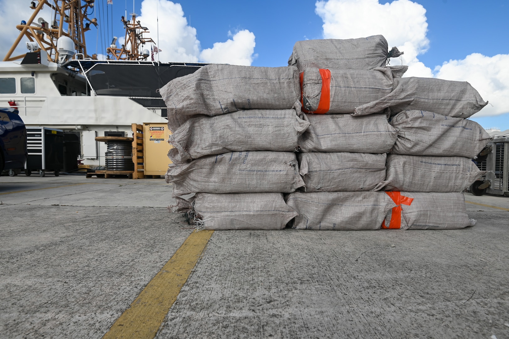 Bales of cocaine stacked on a pier at Base Miami Beach on August 14, 2024. This offload was the result of drug interdiction efforts by Coast Guard and Navy crews in the international waters of Caribbean. (U.S. Coast Guard photo by Petty Officer 3rd Class Nicholas Strasburg)