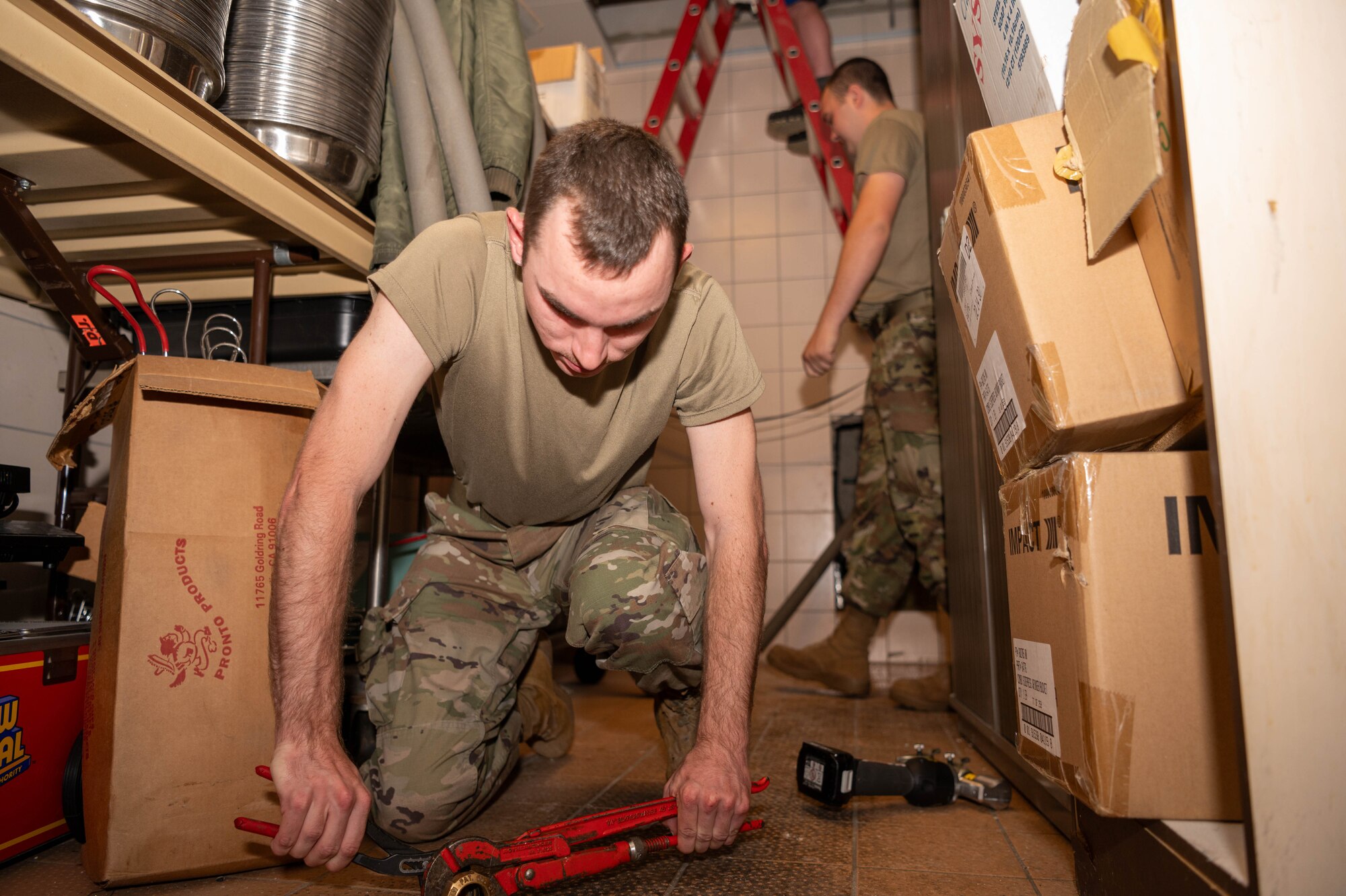A man fixes a pipe with a pipe wrench.