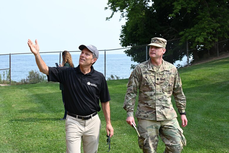 An Army officer and a civilian walk across the lawn at Old Fort Niagara in Youngstown, New York