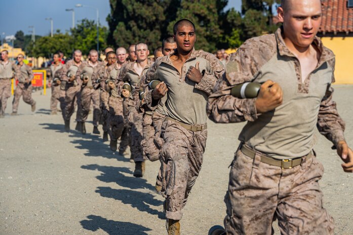 U.S Marine Corps recruits with Bravo Company, 1st Recruit Training Battalion, run with canteens before a confidence course training event at Marine Corps Recruit Depot San Diego, California, Aug. 5, 2024. The confidence course challenges recruits physically and mentally through obstacles that require confidence in their strength, balance, and determination. (U.S. Marine Corps photo by Lance Cpl. Eric Valerio)