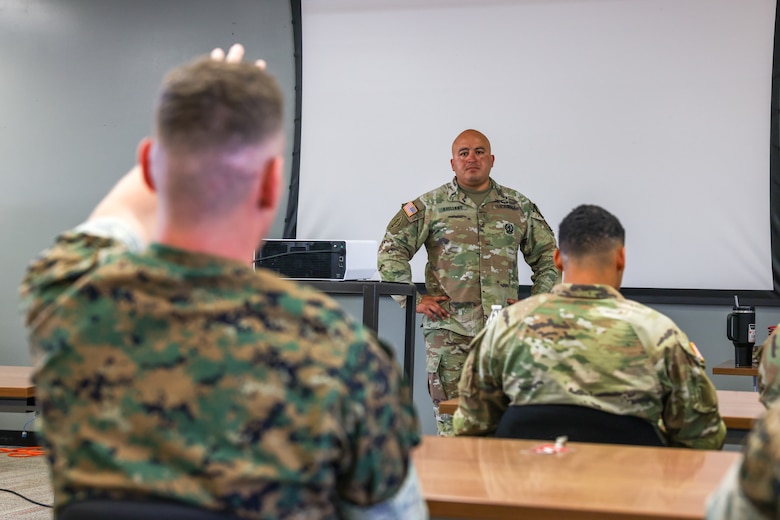 U.S. Army Chief Warrant Officer 3 Jesus Arellano, the Air Defense Artillery Fire Control Officer course manager with 2nd Battalion, 6th Air Defense Artillery Regiment, 30th Air Defense Brigade, conducts an end of course discussion with students of the ADAFCO course at Marine Corps Base Camp Pendleton, California, July 25, 2024. Marine Air Support Squadron 3 hosted its first three-week U.S. Army ADAFCO course, with 10 soldiers and four Marines. The ADAFCO course is designed to teach and develop the necessary skills to integrate Army Air and Missile Defense engagement operations. (U.S. Marine Corps photo by Lance Cpl. Jennifer Sanchez)