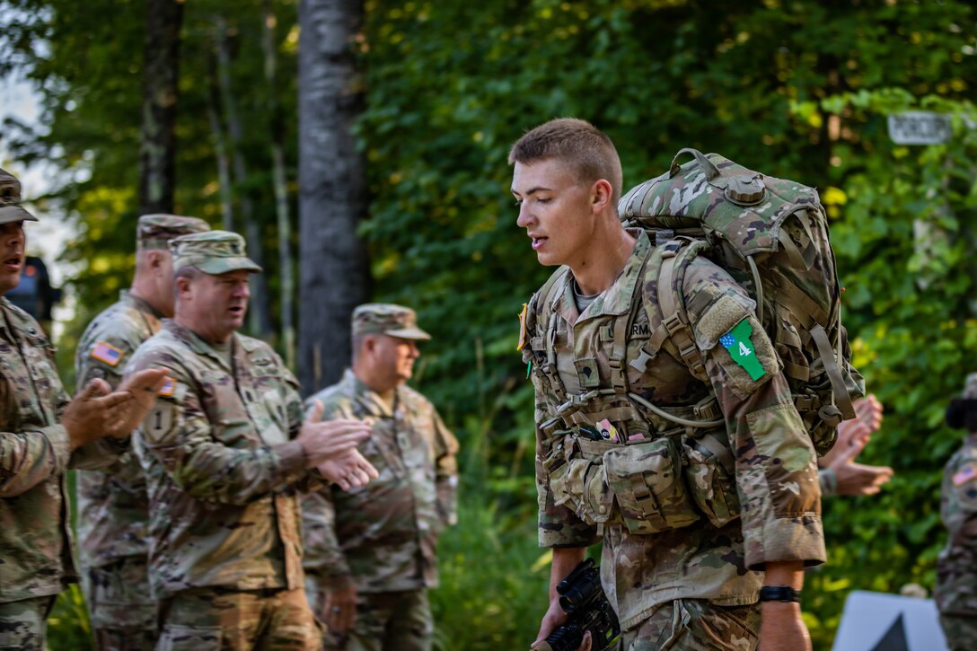 Spc. Tevin Kenton, an infantryman representing the Wisconsin Army National Guard, rucks through steep terrain Aug. 8 in the 12-mile final event during the 2024 Army National Guard Best Warrior Competition at the Army Mountain Warfare School, Jericho, Vt. Command Sgt. Maj. Duane Weyer, the state command sergeant major for the Wisconsin Army National Guard, cheers Kenton on. The Army National Guard Best Warrior Competition is a five-day event composed of 14 competitors representing the regional winners; the competition tests Soldiers’ physical and mental prowess with a series of events with the overall winners receiving either Soldier of the Year or Non-commissioned Officer of the Year recognition. U.S. Army National Guard photo by Sgt. Lianne M. Hirano