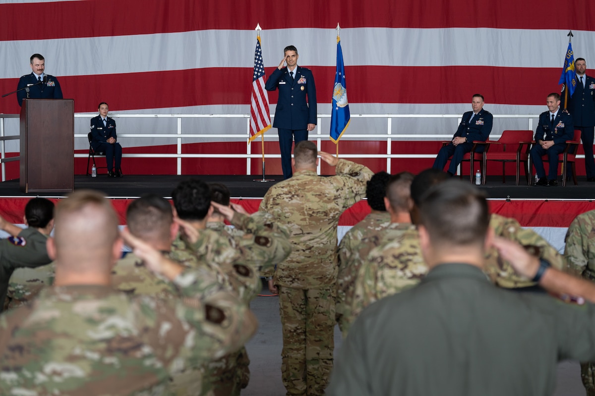 A group of Airmen saluting a commander on stage