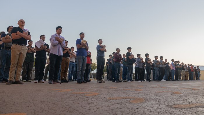U.S. Marine Corps recruits with Hotel Company, 2nd Recruit Training Battalion, stand on the yellow footprints as part of a receiving event at Marine Corps Recruit Depot San Diego, California, Aug. 12, 2024. During the receiving process recruits are checked for contraband, given haircuts, make a scripted phone call home, and are issued the gear required for their training.  (U.S. Marine Corps photo by Lance Cpl. Janell B. Alvarez)
