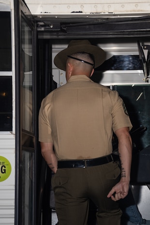 U.S. Marine Corps Staff Sgt. Asen Poole, a drill instructor with Receiving Company, Support Training Battalion, steps on a bus to brief recruits with Hotel Company, 2nd Recruit Training Battalion, during a receiving event at Marine Corps Recruit Depot San Diego, Aug. 12, 2024. During the receiving process recruits are checked for contraband, given haircuts, make a scripted phone call home, and are issued their gear required for training. (U.S. Marine Corps photo by Lance Cpl. Janell B. Alvarez)