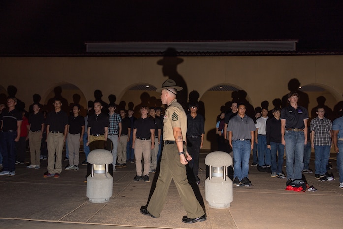 U.S. Marine Corps Staff Sgt. Asen Poole, a drill instructor with Receiving Company, Support Training Battalion, briefs recruits with Hotel Company, 2nd Recruit Training Battalion, during a receiving event at Marine Corps Recruit Depot San Diego, Aug. 12, 2024. During the receiving process recruits are checked for contraband, given haircuts, make a scripted phone call home, and are issued their gear required for training. (U.S. Marine Corps photo by Lance Cpl. Janell B. Alvarez)