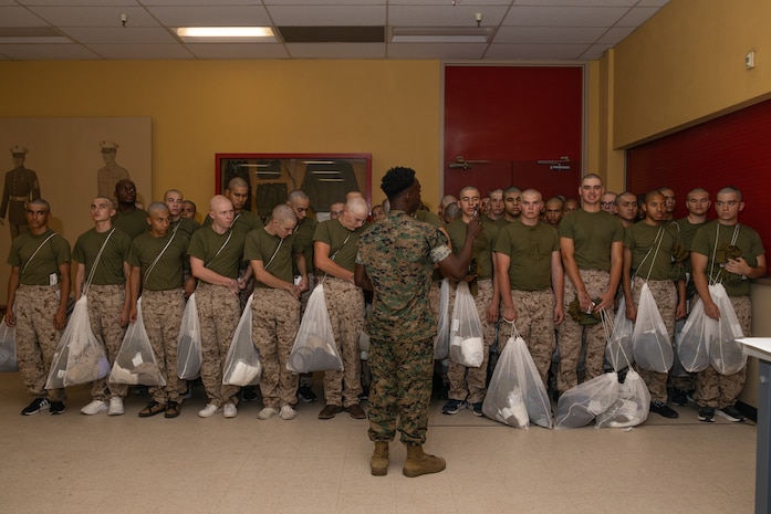 U.S. Marine Corps Pfc. Zachary Thomas, a warehouse clerk with Headquarters and Service Battalion, Marine Corps Recruit Depot San Diego, briefs recruits with Hotel Company, 2nd Recruit Training Battalion, during a receiving event at MCRD San Diego, Aug. 12, 2024. During the receiving process recruits are checked for contraband, given haircuts, make a scripted phone call home, and are issued their gear required for training. (U.S. Marine Corps photo by Lance Cpl. Janell B. Alvarez)