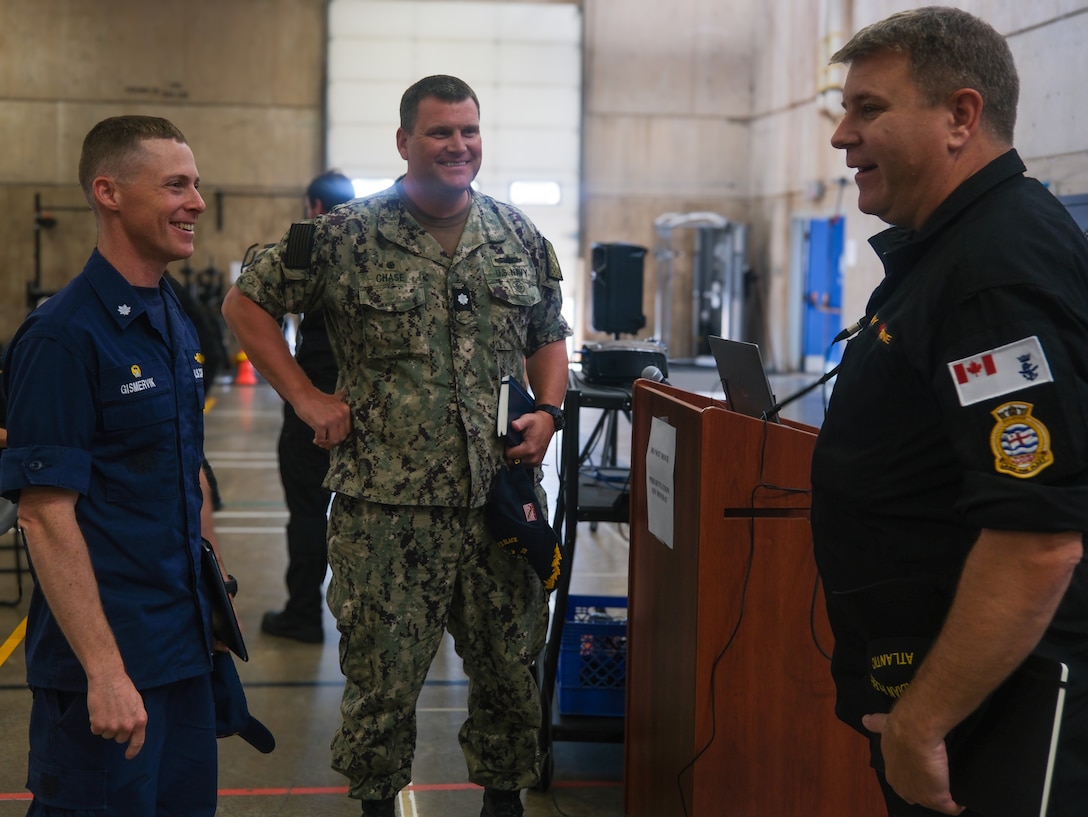 U.S. Coast Guard Cmdr. Brian Gismervik, commanding officer of Coast Guard Cutter Northland (WMEC 904), U.S. Navy Cmdr. Jeremiah Chase, commanding officer of Arleigh Burke-class guided-missile destroyer USS Delbert D. Black (DDG 119) and Royal Canadian navy Capt. Gord Noseworthy, commander of Task Group 300.10, talk at a pre-sail conference for Operation Nanook, Aug. 12, 2024, in Halifax, Nova Scotia. Operation Nanook is an international exercise led by Canada to increase mission readiness in the Arctic. (U.S. Coast Guard photo by Petty Officer 3rd Class Anthony Randisi)