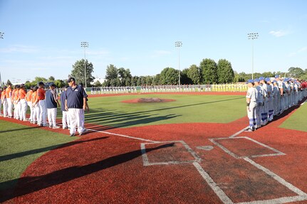 American Legion Great Lakes baseball tournament players line the baseball diamond at Lee Pfund field prior to the National Anthem, August 7, 2024, during the American Legion Post 76-hosted state champion baseball tournament for the Great Lakes region.