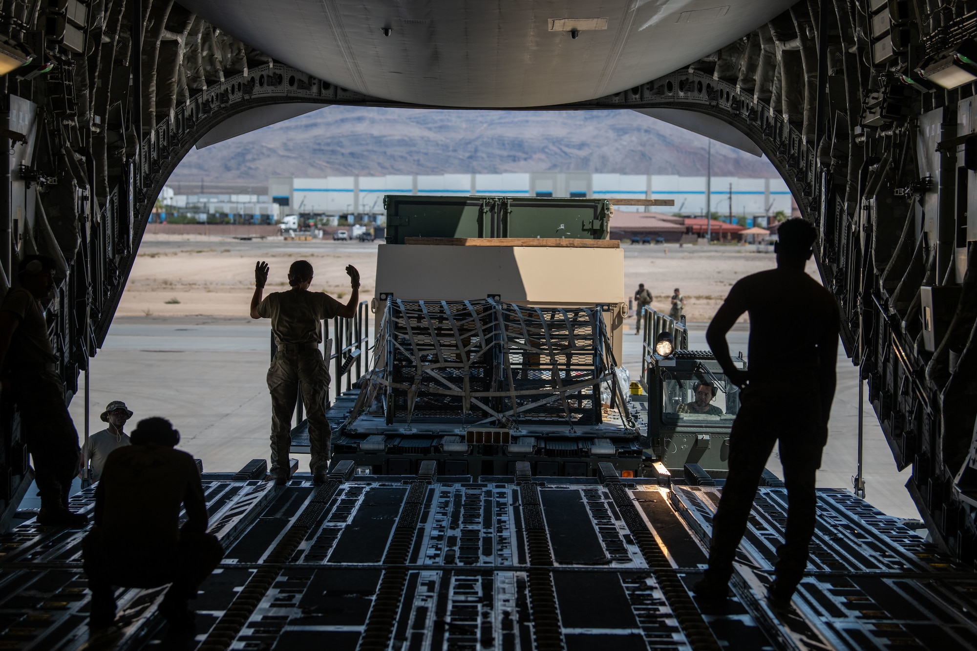 U.S. Air Force Airman 1st Class Candice Barr, 15th Airlift Squadron loadmaster, positions a K-loader to drop off cargo onto a C-17 Globemaster III in preparation for exercise Bamboo Eagle 24-3 at an airfield in the western region of the U.S., August 3, 2024. Bamboo Eagle 24-3 is an example of how the Air Force implements large scale exercises and mission-focused training that encompasses multiple operational plans to demonstrate and rehearse for complex military operations. (U.S. Air Force photo by Senior Airman Christian Silvera)