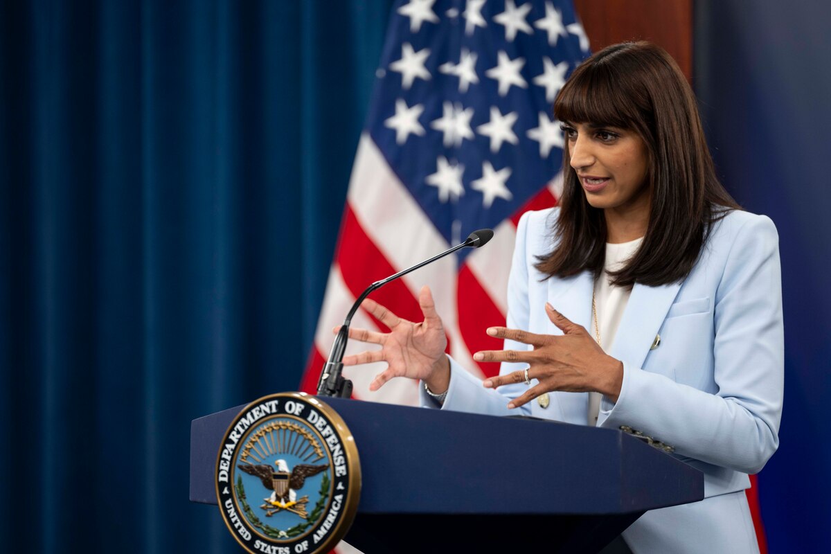 A spokesperson speaks from a lectern with an American flag and curtains in the backdrop.