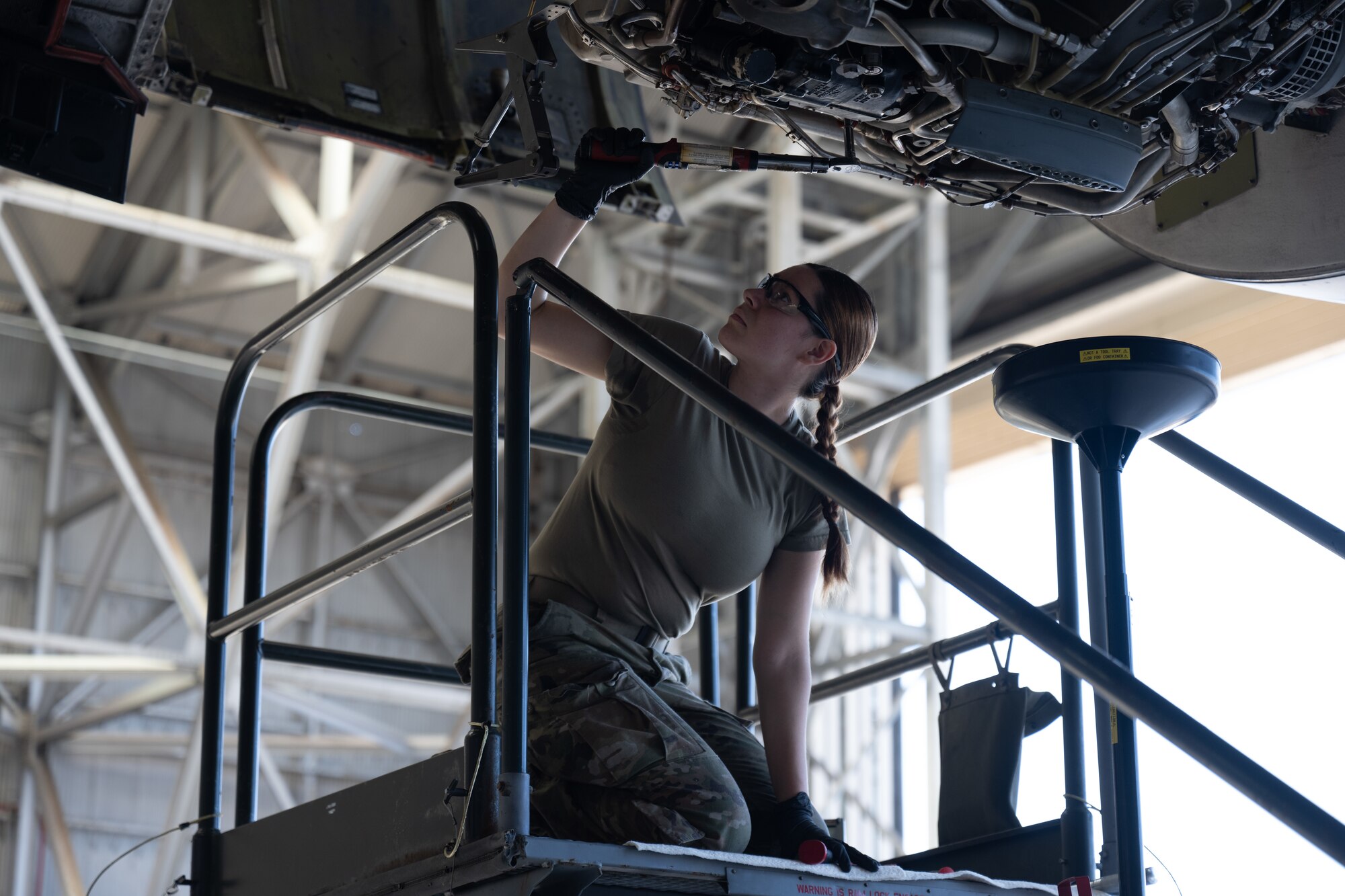 Airman performs maintenance on an aircraft engine.