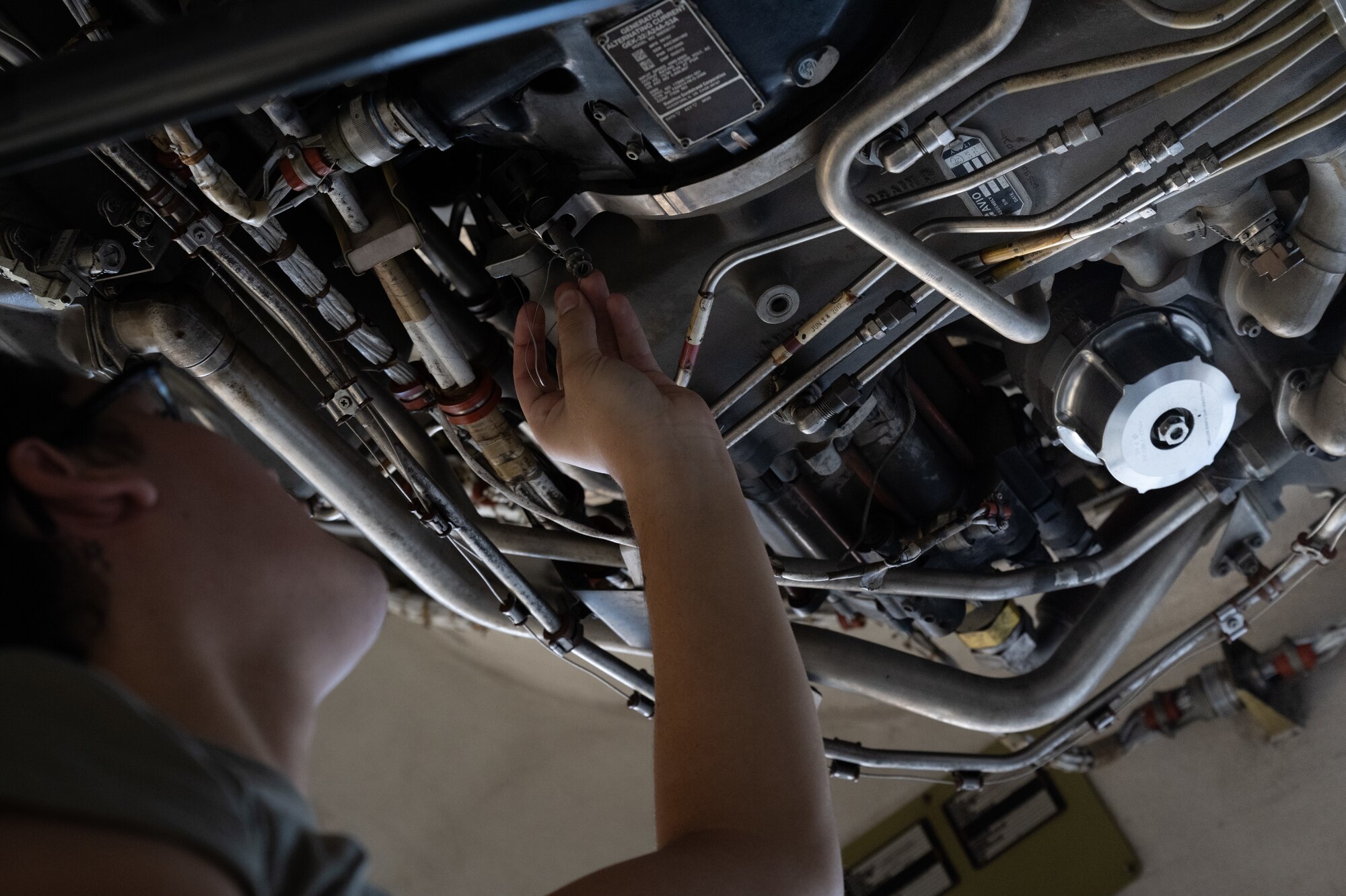 Airman maintains aircraft engine.