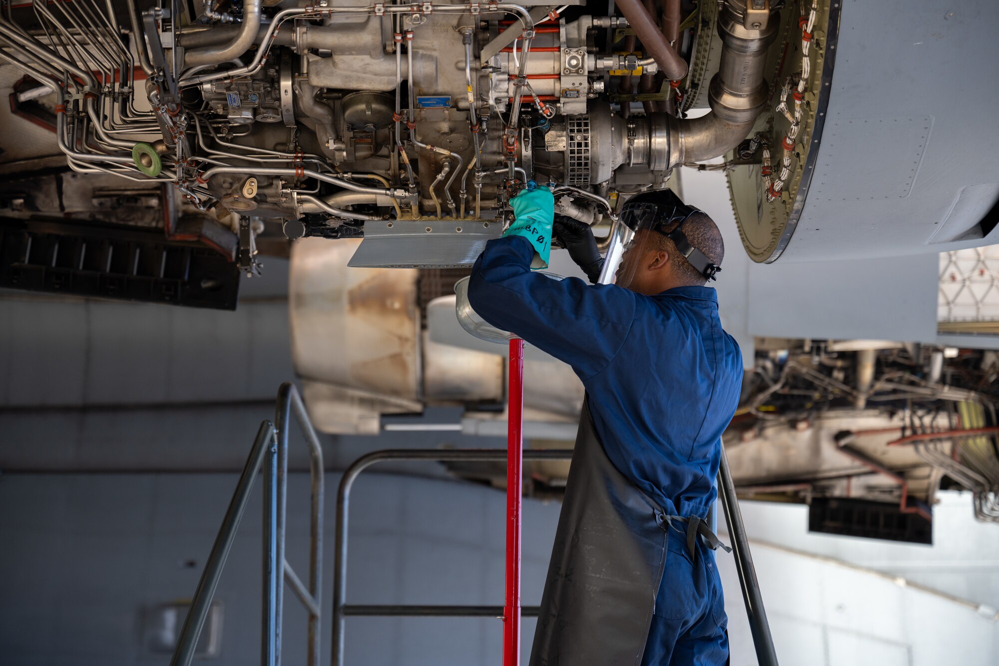 Airman maintains aircraft engine.