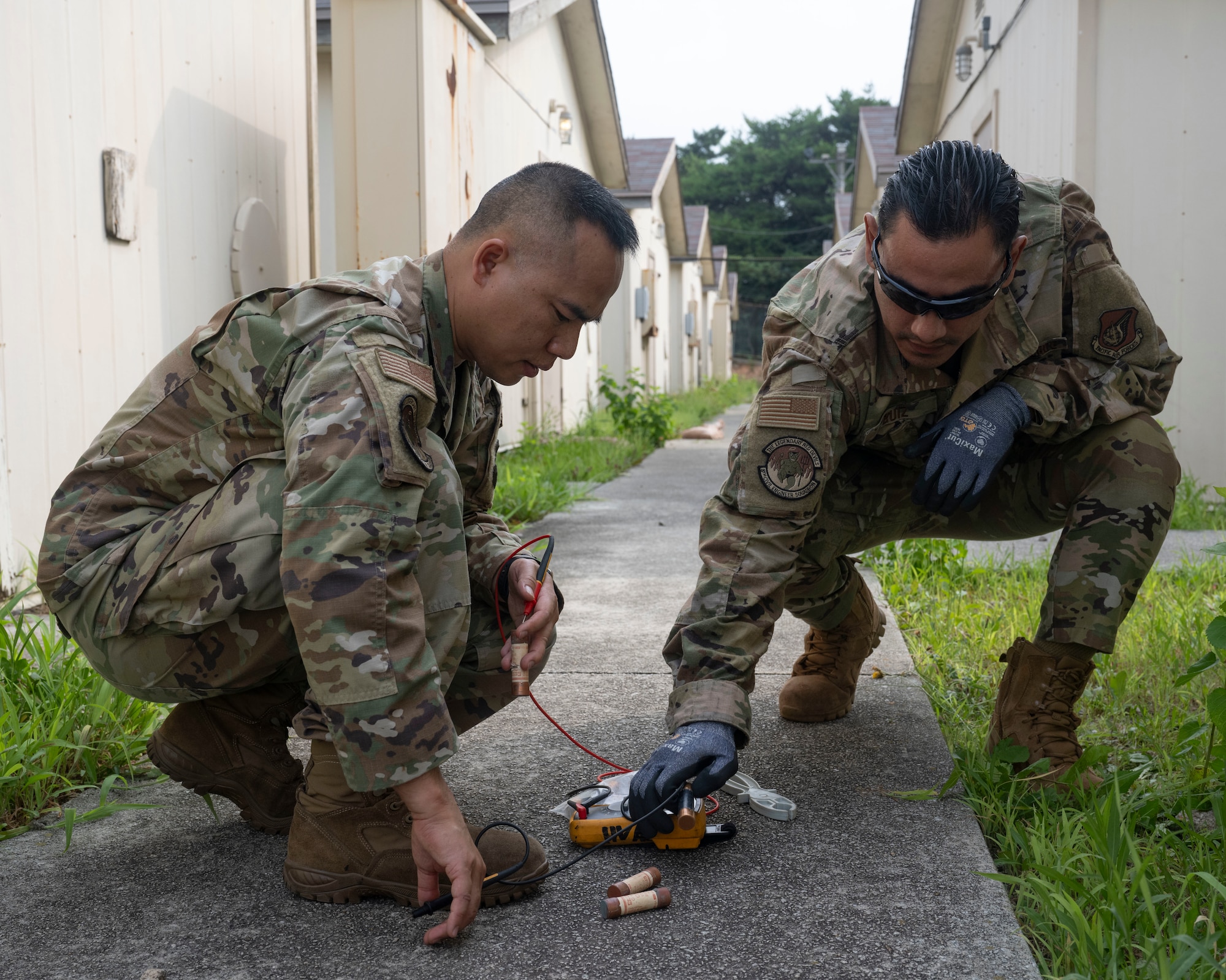 Senior Airman Intorn Messa, left, and U.S. Air Force Staff Sgt. Javier Ruiz, right, 8th Civil Engineer Squadron heating ventilation, air conditioning and refrigeration journeymen, test the fuses of a building at Kunsan Air Base, Republic of Korea.