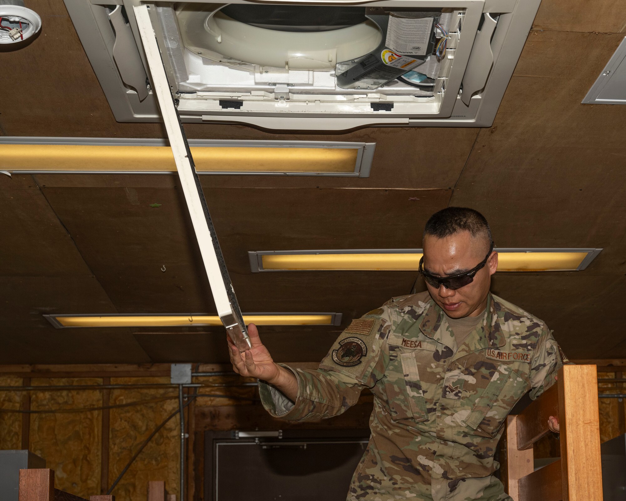 Senior Airman Intorn Meesa, 8th Civil Engineer Squadron heating ventilation, air conditioning and refrigeration journeyman, opens an AC cover at Kunsan Air Base, Republic of Korea