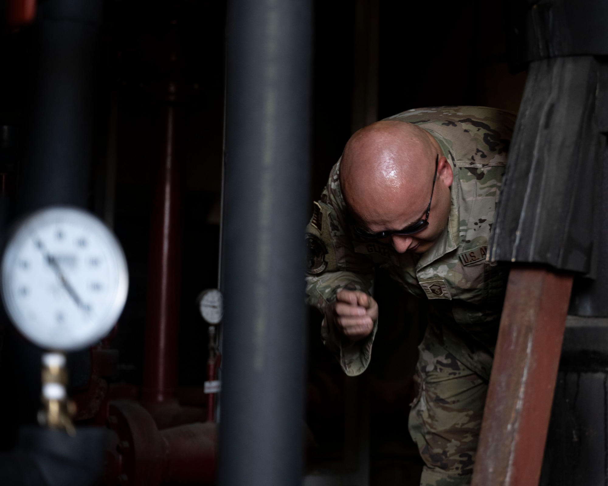 U.S. Air Force Master Sgt. Lyle Glatz, a heating, ventilation, air conditioning and refrigeration technician assigned to the 263rd Combat Communication Squadron, North Carolina Air National Guard, inspects water pipes for pressure and leaks at Kunsan Air Base, Republic of Korea.
