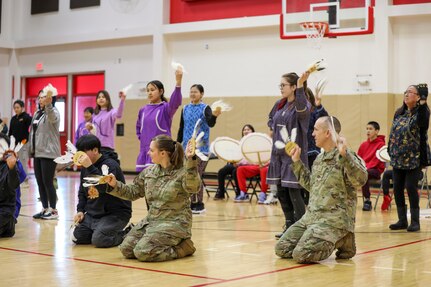 Alaska Air and Army National Guardsmen join students from the Andreafski High School as they perform a perform a traditional Yup’ik dance in St. Mary’s, Alaska, March 31, 2023. The AVCP recently partnered with the Alaska National Guard to provide recruiting information and resources through their Tribal Job Centers.