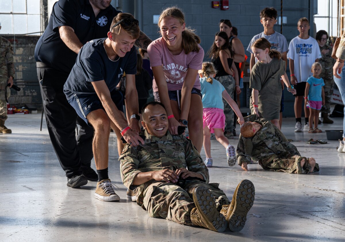 Children of service members assigned to Wright-Patterson move a simulated injured Airman during a Kids Understanding Deployment Operations event at Wright-Patterson Air Force Base, Ohio, Aug. 9, 2024.