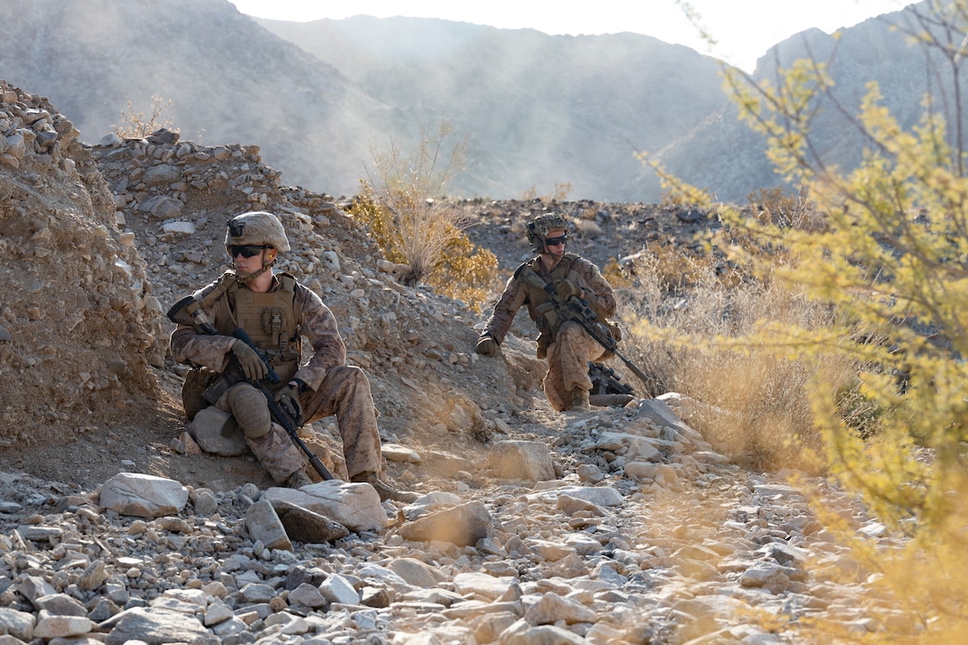 U.S. Marine Corps Cpl. Zebulon Helton, an infantry Marine with 1st Battalion, 2nd Marine Regiment, 2nd Marine Division, left, prepares to pass through an obstacle during company attacks as part of Service Level Training Exercise 5-24 at Range 400, Marine Corps Air-Ground Combat Center, Twentynine Palms, California, July 25, 2024. SLTE 5-24 is purpose built to train, develop, and validate the Infantry Battalion Experiment as part of a larger Marine Air-Ground Task Force operation as a Stand-in Force across a contested multi-domain distributed environment. ITX enables units to mobilize geographically dispersed forces for potential future deployments, increase combat readiness and lethality, and exercise Marine Air-Ground Task Force command and control of battalions and squadrons across the full spectrum of warfare. (U.S. Marine Corps photo by Lance Cpl. Enge You)