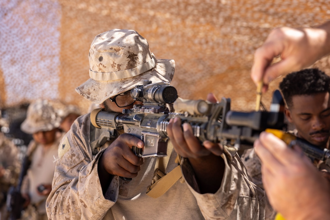 U.S. Marine Corps Lance Cpl. Jakobe Hartford, an infantry Marine with 3rd Battalion, 5th Marine Regiment, 1st Marine Division, calibrates his Marine Corps Tactical Instrumentation System gear during an Integrated Training Exercise as part of Service Level Training Exercise 5-24 at Range 220, Marine Corps Air-Ground Combat Center, Twentynine Palms, California, July 31, 2024. The MCTIS is a four-piece battery powered system that provides a realistic simulation of combat to give Marines accurate instant information while in the field, and records movement in real time in the battlefield. SLTE 5-24 is purpose built to train, develop, and validate the Infantry Battalion Experiment as part of a larger MAGTF operation as a Stand-in Force across a contested multi-domain distributed environment. (U.S. Marine Corps photo by Lance Cpl. Anna Higman)