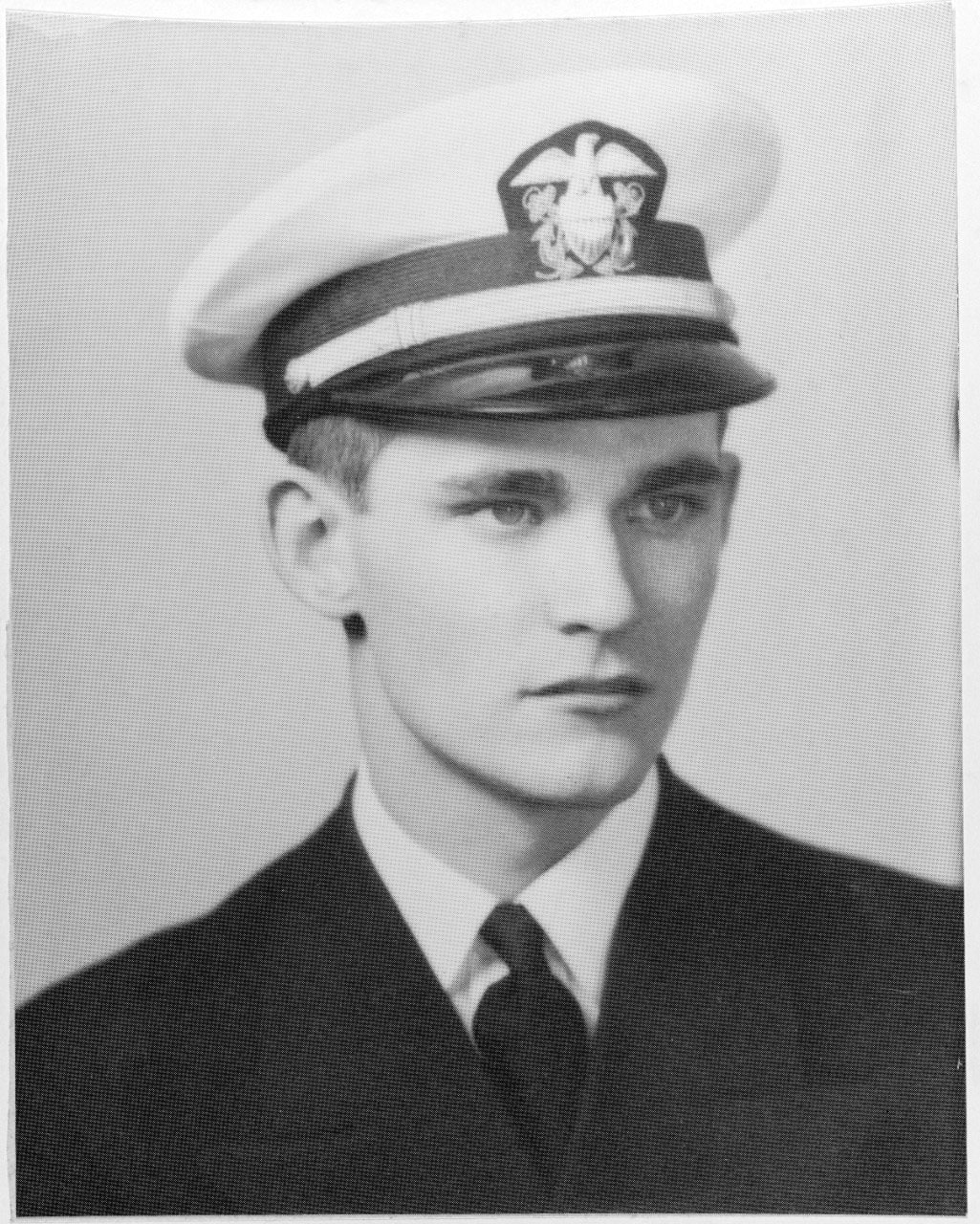 A sailor wearing a hat poses in a black and white photo.