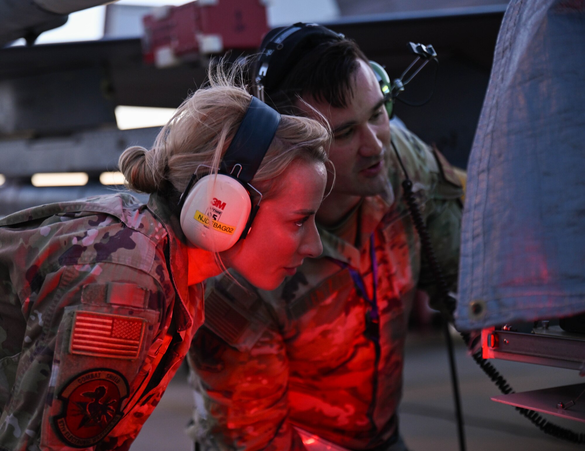 U.S. Air Force Lt. Col. Vanessa Gasswint, left, 87th Electronic Warfare Squadron commander, and U.S. Air Force Staff Sgt. Stephen Lentz, 87th Electronic Warfare Squadron Combat Shield avionics electronic warfare (EW) technician, look at the screen of an AN/USM-642A during Bamboo Eagle 24-3 at Southern California Logistics Airport, Victorville, California, Aug. 5, 2024. Through the use of designated airspace, BE 24-3 provides Airmen, allies and partners a flexible, combat-representative, multidimensional battlespace to conduct testing, tactics development, and advanced training in support of U.S. national interests. (U.S. Air Force photo by Senior Airman Anna Smith)